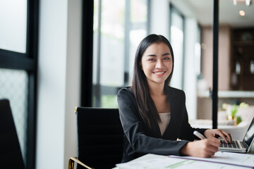 Fototapeta premium Portrait of asian woman working on desk at contemporary corporation office.