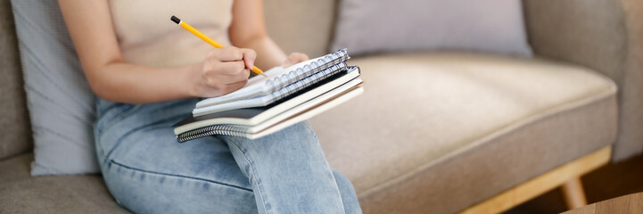 Creative designer woman sitting on sofa to sketching graphic design with new project in home studio