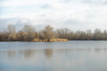 Sad autumn river landscape with cloudy sky