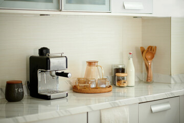 Coffee station at home with jar of water, bottle of milk and coffee machine