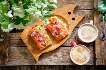 toast with cucumber, chives and salmon. Top view, wooden background