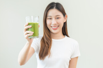 Green detox juice concept, Beautiful asian young woman hand holding vegetable smoothie glass for diet on background. Happy girl drinking healthy meal food for weight loss. Lifestyle, vegan nutrition.