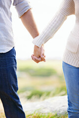 Holding hands, closeup and couple on holiday at beach with love, trust and support on journey together. Marriage, man and woman in nature, walking with care and respect for partnership or bonding