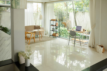 Spacious living room area with small desk for home office