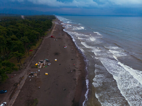 Drone aerial view of the beach with black magnetic sands in Georgia. Storm waves, garbage on the Ureki beach after bad weather, no swimming. Danger on the water for vacationers. Cumulonimbus.