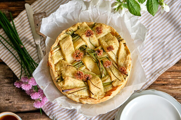 Pie with whole boiled eggs, salmon, cheese, chives. White background.
