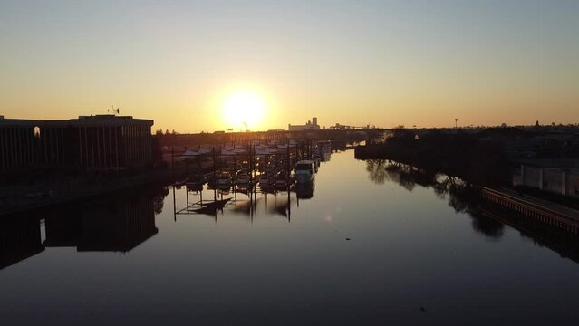 Drone flight over McLeod Lake on the San Joaquin River in Stockton, California.  Sunset flight close to Downtown.  Industrial background.