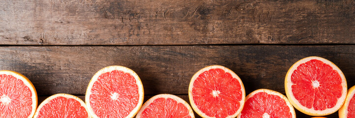 Juicy grapefruit slices on wooden table - obrazy, fototapety, plakaty