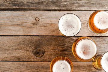 Overhead shot of beer glasses on wooden table.