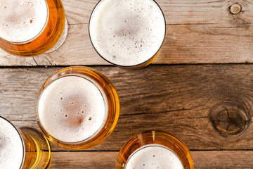 Overhead shot of beer glasses on wooden table.