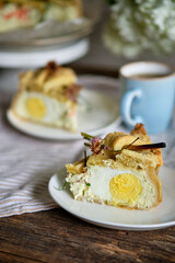 a piece of Pie with whole boiled eggs, salmon, cheese, chives. White background.