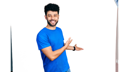 Young arab man with beard wearing casual blue t shirt inviting to enter smiling natural with open hand