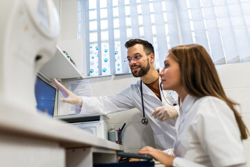 Veterinarians working in laboratory. Vet doctors are examining sample at animal hospital.