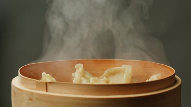 Japanese gyoza on wooden steamer close-up. Fried dumplings with meat. Steaming Technique. Cooking at cafe, restaurant. Homemade. Delivery