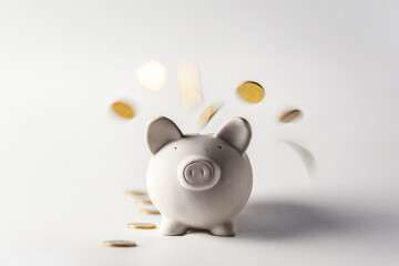 Gold coins pour into a piggy bank from above. Pig money box with falling golden coins