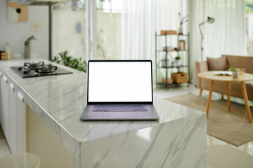 Laptop with empty screen on kitchen counter