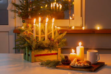 white cup with hot drink and christmas decorations at home