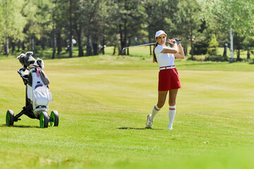 Portrait of athletic woman playing golf on course outdoors