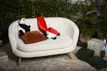 Christmas interior with a white sofa near green Christmas trees with lights that create a bokeh...