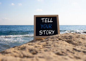 Tell your story symbol. Concept words Tell your story on black chalk blackboard. Beautiful sea background. Business and Tell your story concept. Copy space.