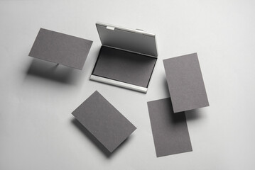 Composition of floating business cards and metal box holder on gray background. Business concept