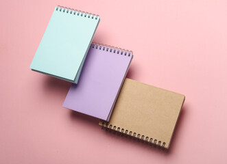 Composition of floating notepads on pink background