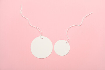 White blank round tags on string, pink background