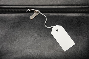 White blank tags with string on leather bag