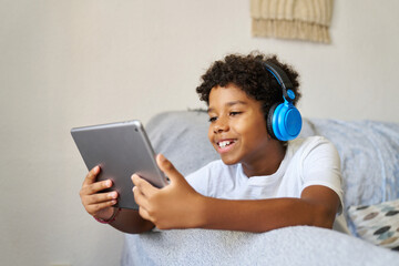 Smiling boy with touchpad on sofa