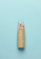 Box with wooden colored pencils on a blue background. Creativity, art