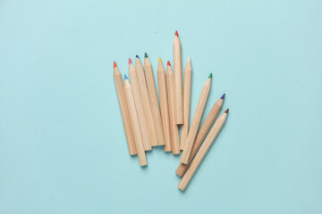 Wooden colored pencils on blue background. Creativity, art