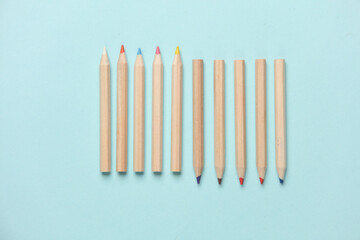 Set of wooden colored pencils on a blue background. Creativity, art