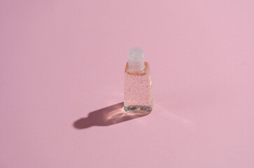 Antiseptic bottle on a pink background with shadow