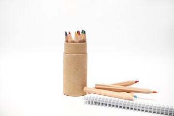 Wooden colored pencils and sketchbook on white background. Creativity, art