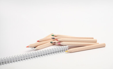 Wooden colored pencils and sketchbook on white background. Creativity, art