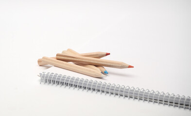 Wooden colored pencils and sketchbook on white background. Creativity, art