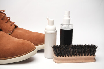 Fototapeta na wymiar Suede boots and Shoe care products or accessories on a white background