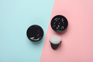 Shoe polish jar with sponge on pink blue background. Top view