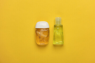 Antiseptic bottles on yellow background. Top view