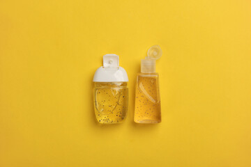 Antiseptic bottles on yellow background. Top view