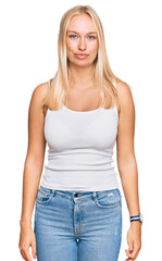 Fototapeta premium Young blonde girl wearing casual style with sleeveless shirt looking sleepy and tired, exhausted for fatigue and hangover, lazy eyes in the morning.