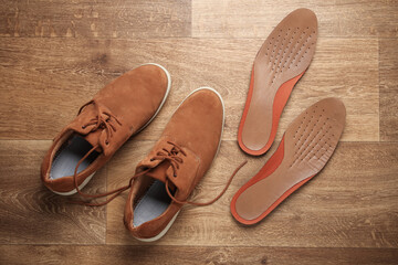 Men's suede shoes with insoles on the floor. Top view