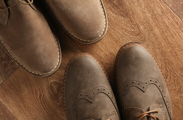 Brogues and desert shoes on a wooden background. Men's style. Top view