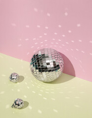 Creative minimal still life with mirrored disco balls on pastel background. Party concept. visual trend. Retro aesthetic