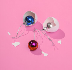 Creative layout with christmas balls in eggshell on bright pink background. Visual trend. Christmas concept. Minimalistic aesthetic still life with shadow. Fresh idea