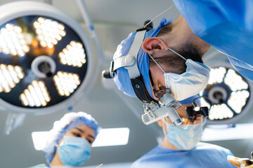 Two surgeons operating on a patient in an operating room. Two Surgeons Performing Neurosurgery in a...