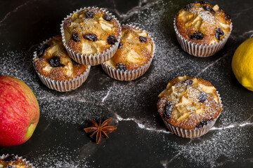 Homemade muffin with apples, raisins and cinnamon sticks. On a dark background