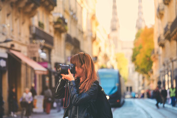 Photographer taking photo on street with tram rails and Saint Andre Cathedral in Bordeaux, France - obrazy, fototapety, plakaty