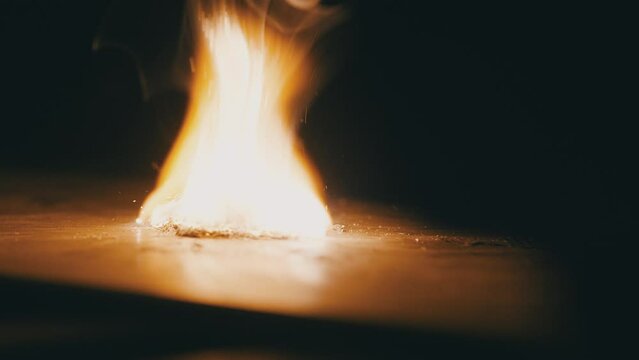 Light the flame. Metal shavings catch fire and burn. Trying to start a fire. Slow motion. High speed camera. 4K video
