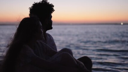 Two lovers gaze at the horizon at sea in Valencia